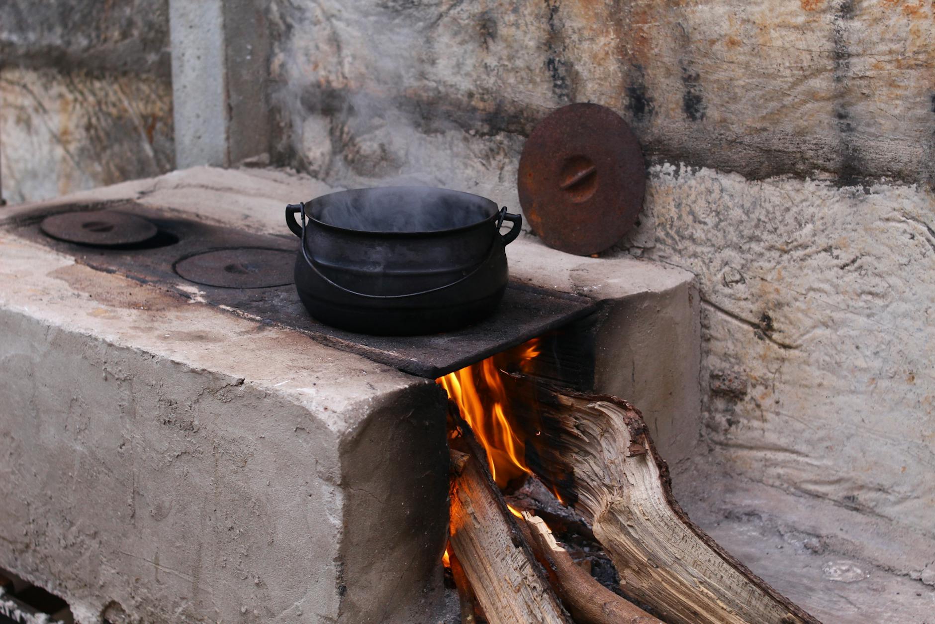 Cast iron Dutch oven on homemade grill setup for resilient families in a digital blackout.