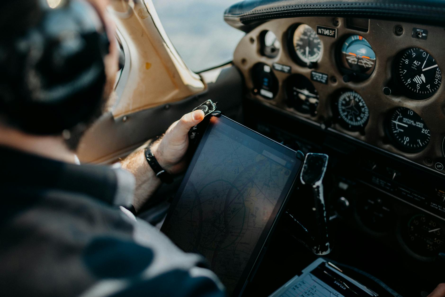 Pilot in cockpit with preparedness checklist on tablet